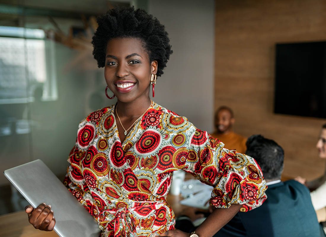 Commercial Umbrella Insurance - Confident Woman Looking Over a Board Room in a Fun Colored Shirt